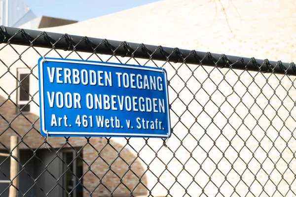 Sign attached to a fence with the Dutch text \'no entry for unauthorized persons, article 461 penal code\'