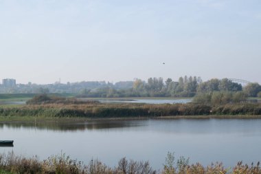 Hollanda 'nın Nijmegen şehrinin ufuk çizgisi önündeki Oude Waal, Gelderland