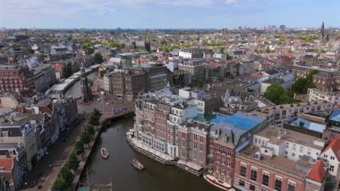 Breathtaking aerial view captures the essence of Amsterdam, highlighting its wellknown canals, remarkable historic architecture, and the lively atmosphere of city life all around