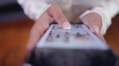 Akıllı telefonu ustalıkla kullanan ellerin yakın görüntüsü modern teknolojinin bugün sunduğu karmaşık dokunmatik ekran etkileşimini etkili bir şekilde gösteriyor.