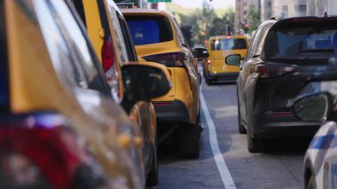 Sarı taksiler ve arabalar yoğun bir New York caddesi boyunca sıkıca doluşarak şehir ulaşımı, günlük ulaşım ve metropol hareketleri için uygun bir şehir trafiği yarattılar.