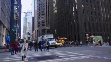 New York 10.28.2025. New York 'ta kalabalık bir caddeden geçen yayalar yüksek binalar ve yemek arabalarıyla şehir hayatı, seyahat ve günlük hareketler için uygun bir şehir manzarası yaratıyorlar.