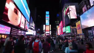 New York 10.28.2025. Times Meydanı New York City, New York 'ta hızlı hareket eden bir gece. Parlayan dijital reklam panoları, değişen kalabalıklar renkli ve enerjik bir atmosfer yaratıyor. Dinamik hızlandırılmış hareket.