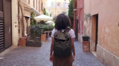 Roma 'da dar tarihi caddelerde sırt çantasıyla gezen genç bir bayan gezgin. Eski şehir mimarisini ve rahat şehir atmosferini keşfediyor.