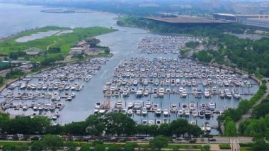 Chicago Illinois yat limanının sinematik görüntüsü bugün gündüz vakti yüzlerce tekne, liman havzası, yeşil kıyı şeridi, göle erişim ve yaz şehri atmosferini gösteriyor..
