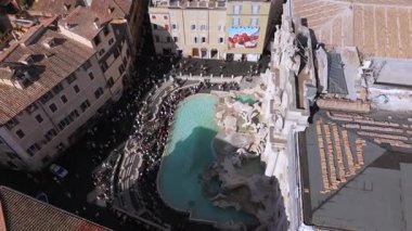 Roma 08.08.2025. Roma 'daki Trevi Çeşmesi' nin sinematik hava manzarası turkuaz su, barok heykeller, tarihi binalar ve şehir merkezinde yoğun turist kalabalığı ile İtalya 'da görülüyor.