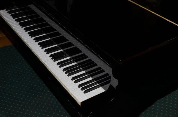 Грандіозне піаніно чорне грає на піаніно Гранд-піаніно в ігровій кімнаті піаніно клавіатури — стокове фото