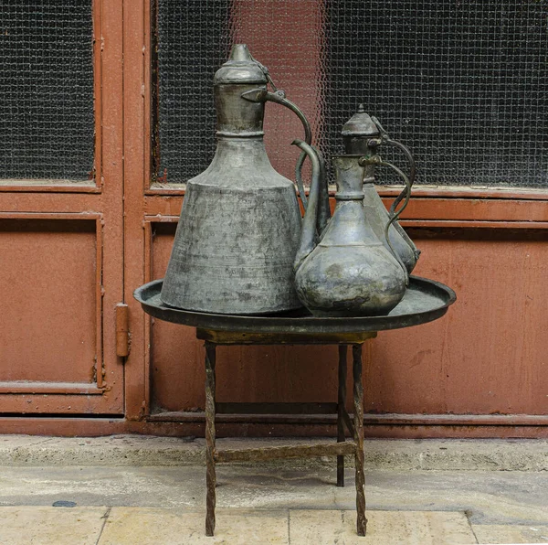 Eski bakır sürahi, kepçe ve kase tepside duruyor.