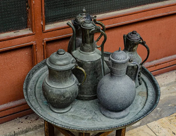 Eski bakır sürahi, kepçe ve kase tepside duruyor.