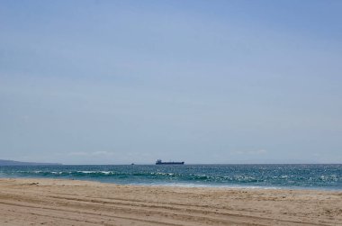 Los Angeles, California, sandy ocean shore ship on the horizon.