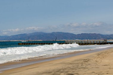 Los Angeles, California, kumlu okyanus kıyısı ufukta dalgalar sahile çarpıyor..