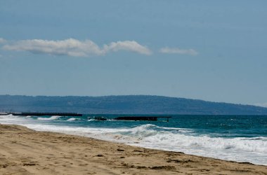 Los Angeles, California, kumlu okyanus kıyısı ufukta dalgalar sahile çarpıyor..