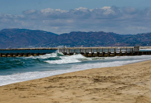 Los Angeles, California, kumlu okyanus kıyısı ufukta dalgalar sahile çarpıyor..