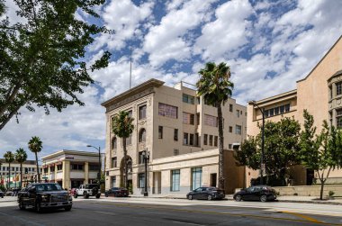 Pasadena, California, ABD, 9 Eylül 2025 Palmiye ağaçları, trafik, dükkanlar ve yayalar ile Sunny California şehir caddesi.