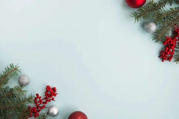 Açık mavi arka planda tatil süslemeleri olan Noel ağacı dalları. Mutlu Noeller, mutlu yıllar tebrik kartı ya da kış kompozisyonu. Üst görünüm, düz görünüm, kopyalama alanı, çerçeve