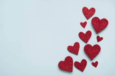 Sevgililer Günü. Açık mavi arka planda parlak kırmızı kalpler. Üst görünüm, düz görünüm, kopyalama alanı