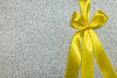 Gümüş renkli parlak kart, sertifika ya da sarı kurdeleli kumaş hediye kutusu. Doğum günü, yıldönümü, Noel geçmişi. Üst görünüm, düz görünüm, kopyalama alanı, tasarım şablonu