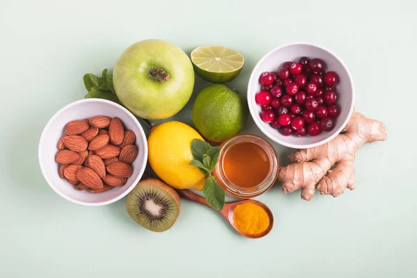 緑の背景に増加免疫のための健康的な食品 レモン クランベリー ジンジャールート キウイ リンゴ ミント ナッツ ターメリック ビタミンと製品 — ストック写真