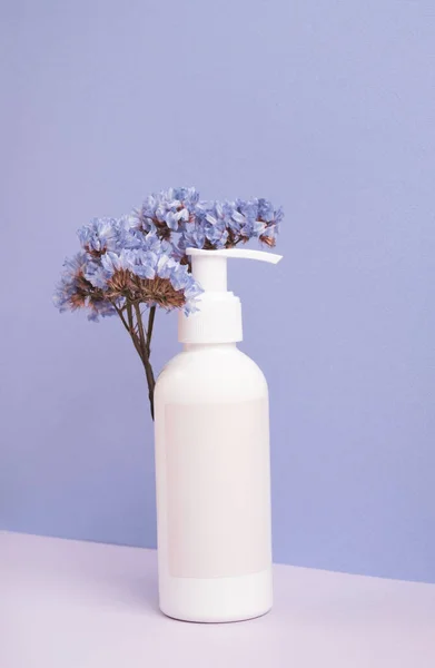 Cosmetische Fles Met Blanco Eetbaar Bloemen Pastelpaarse Achtergrond Schoonheidsbehandeling Concept — Stockfoto