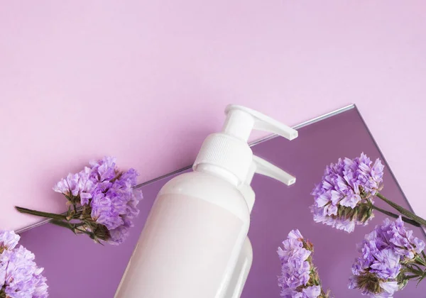 Cosmetische Fles Met Bloemen Een Spiegel Paars Oppervlak Onderwerp Natuurlijke — Stockfoto