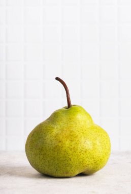 Arka plandaki masada sulu bir armut. Dikey, kapat