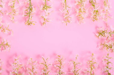 Tebrik kartı, pembe zemin üzerinde seçici odaklı bir fotokopi alanı olan bir çerçeve şeklinde narin beyaz çiçekler.