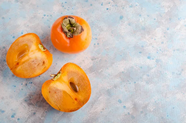 Masadaki hurmalar, bütünüyle ve kopyalama alanı olan gri-mavi bir arkaplanda kes