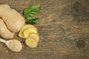 Kırpılmış takozlu zencefil kökü ve tahta zemin üzerinde kopyalanmış boşluk