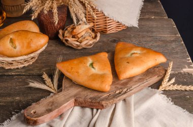 İştah açıcı taze hamur işi. Ahşap arka planda farklı dolguları olan turtalar.