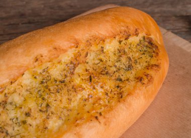 Lezzetli taze ekmek ekmeği ve ahşap arka planda baharatlar.