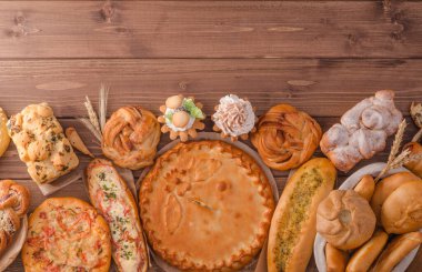 Fotokopi alanı, pastane afişi olan ahşap bir arka planda çeşitli ekmek çeşitleriyle hayat