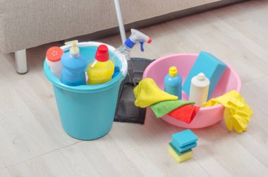İçinde peçeteler, süngerler ve eldivenler olan bir kova dolusu temizlik malzemesi. Evde temizlik konsepti, dairede....