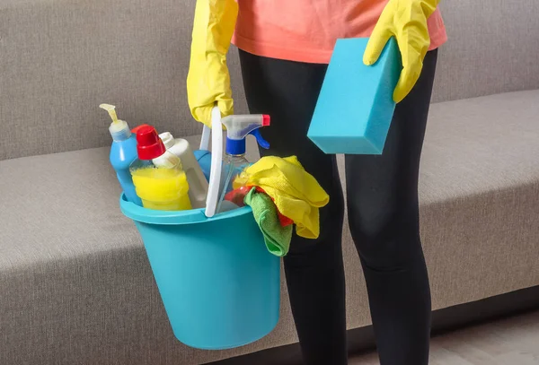 在准备打扫房子 公寓时 一个女人拿着一个装有各种清洁用品和海绵的水桶 — 图库照片