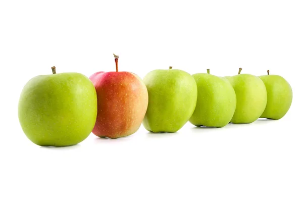 Красное яблоко в ряд зеленых яблок — стоковое фото