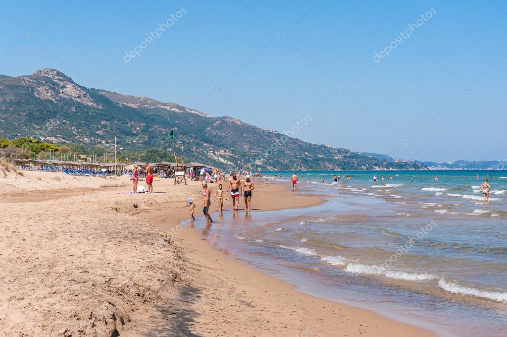 People Sunbathe On The Banana Beach Zakynthos Greece