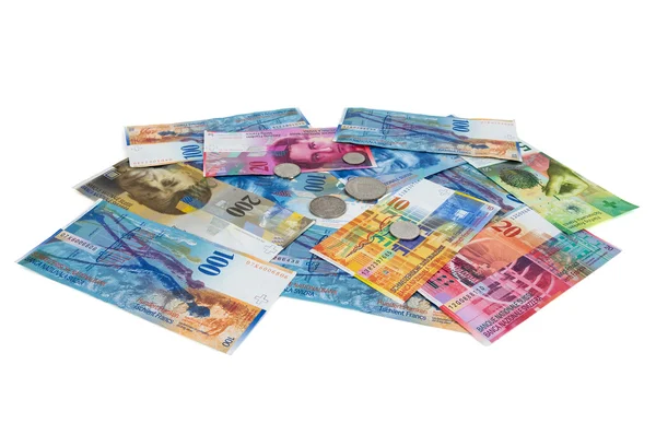 Högen av schweiziska franc sedlar och mynt på vit bakgrund — Stockfoto