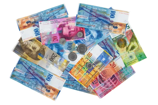 Montón de billetes y monedas en franco suizo sobre fondo blanco — Foto de Stock
