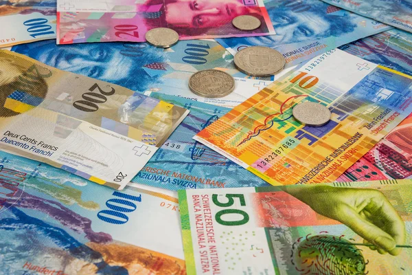 Банкноты и монеты швейцарского франка в фоновом режиме — стоковое фото