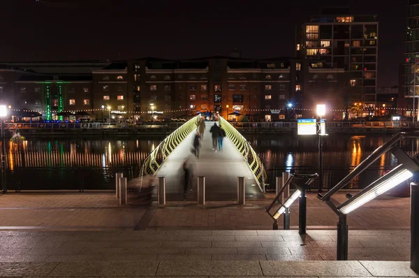 Belysta gångbron i över norra kajen i Canary Wharf nattetid — Stockfoto