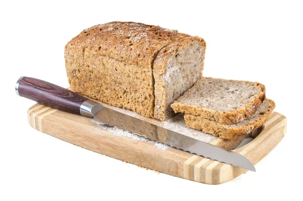 Skära fullkornsbröd och kniv på en skärbräda — Stockfoto