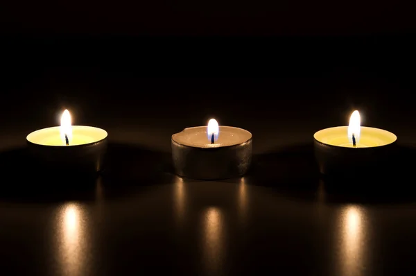 Three burning candles in the dark — Stock Photo, Image