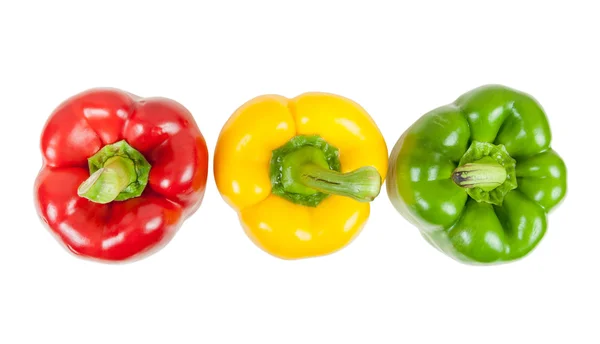 Ovansida av tre färgade paprika på vit — Stockfoto