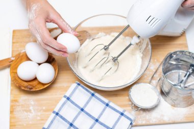 Işık masasında malzemelerle krep pişirme işlemi, yumurta ve un karıştırıcı ile çırpılır