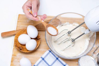 Işık masasında malzemelerle krep pişirme işlemi, yumurta ve un karıştırıcı ile çırpılır