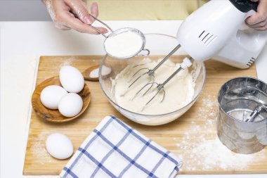 Işık masasında malzemelerle krep pişirme işlemi, yumurta ve un karıştırıcı ile çırpılır