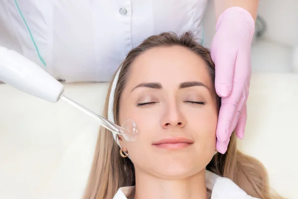 Cosmetologist Executa Procedimento Atual Pulso Para Rosto Uma Jovem Mulher — Fotografia de Stock