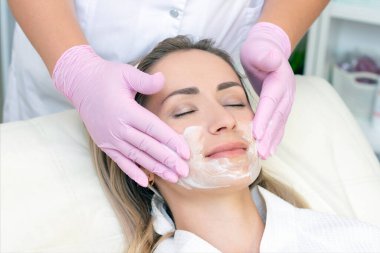 Kozmetoloji. Güzellik salonunda yüz temizleme ameliyatı olan genç bir kadın..