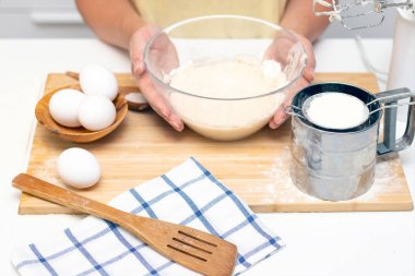 Kahvaltı için ev krepleri için hamur hazırlığı. Masanın üzerindeki buğday unu ve yumurtalar.