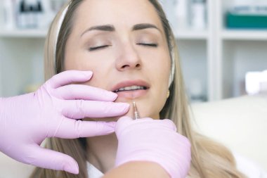 Genç bir kadın kozmetik iğne oluyor. Güzellik salonunda bir kadın. Plastik Cerrahi Kliniği.