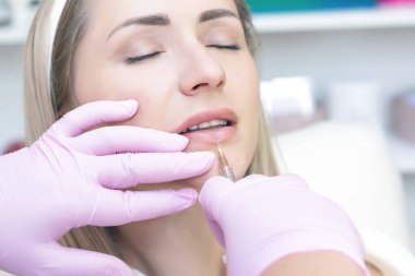 Genç bir kadın kozmetik iğne oluyor. Güzellik salonunda bir kadın. Plastik Cerrahi Kliniği.